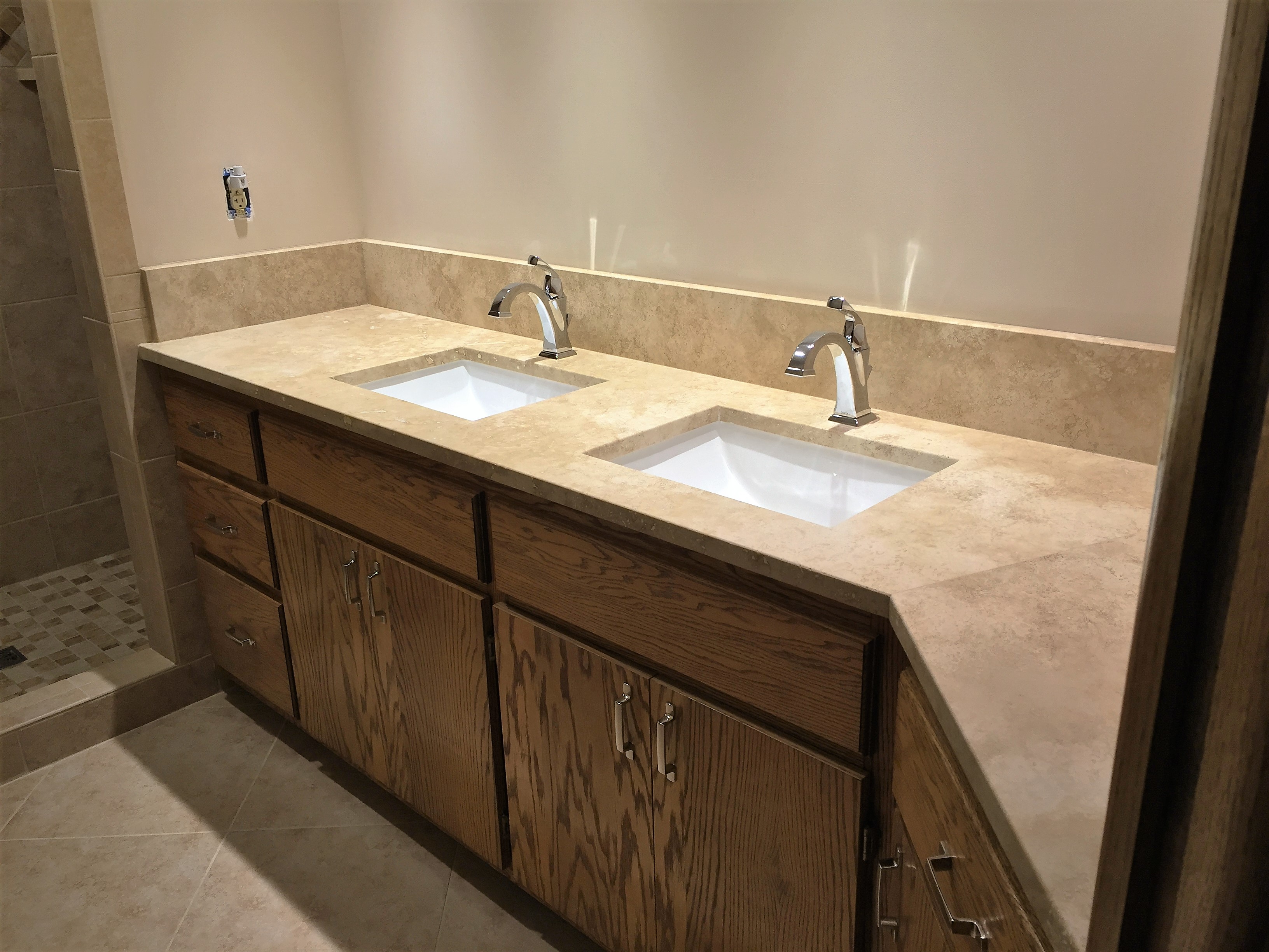 New tan quartz countertop and double sink with chrome fixtures after bathroom remodel
